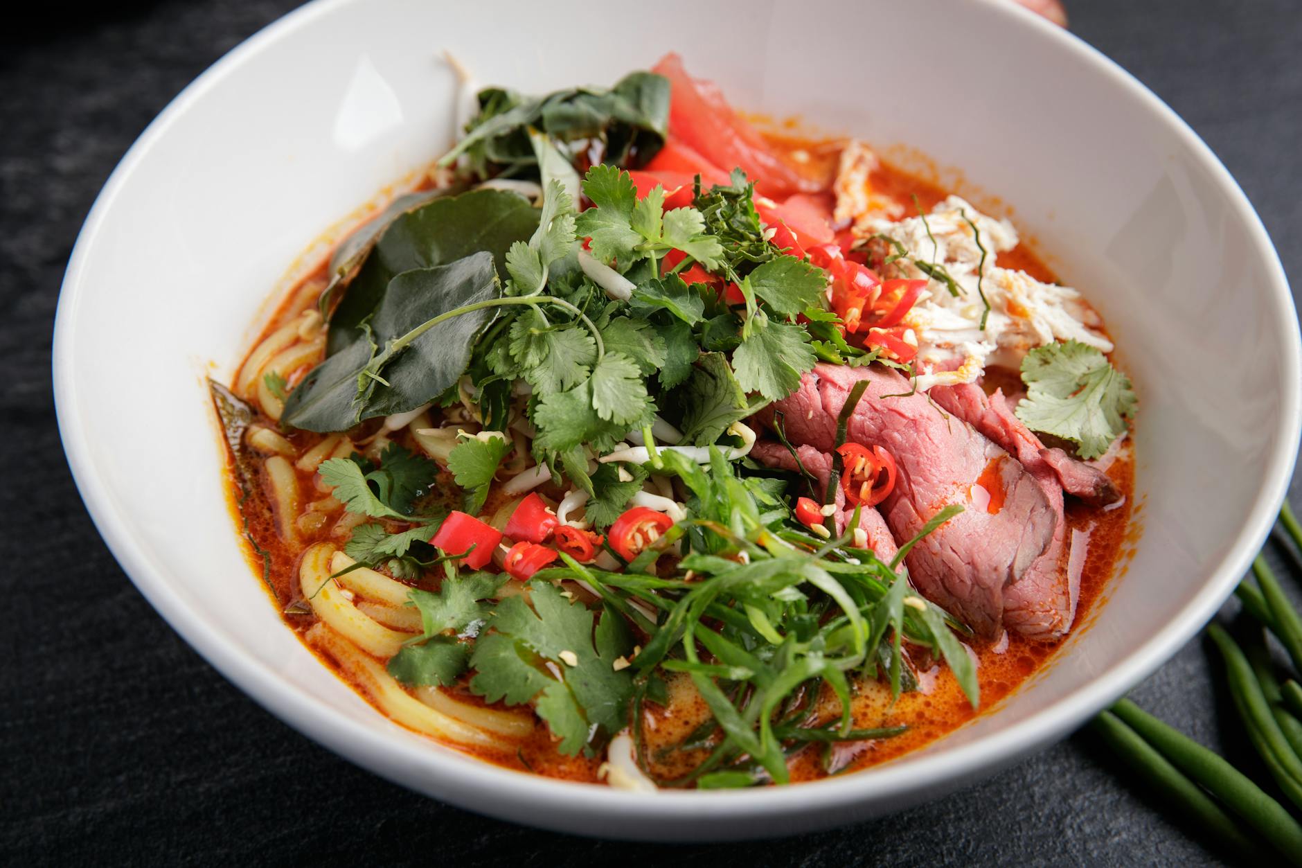Miska ostrej azjatyckiej zupy z wołowiną, makaronem i papryczkami chili Miska ostrej azjatyckiej zupy z wołowiną, makaronem i papryczkami chili