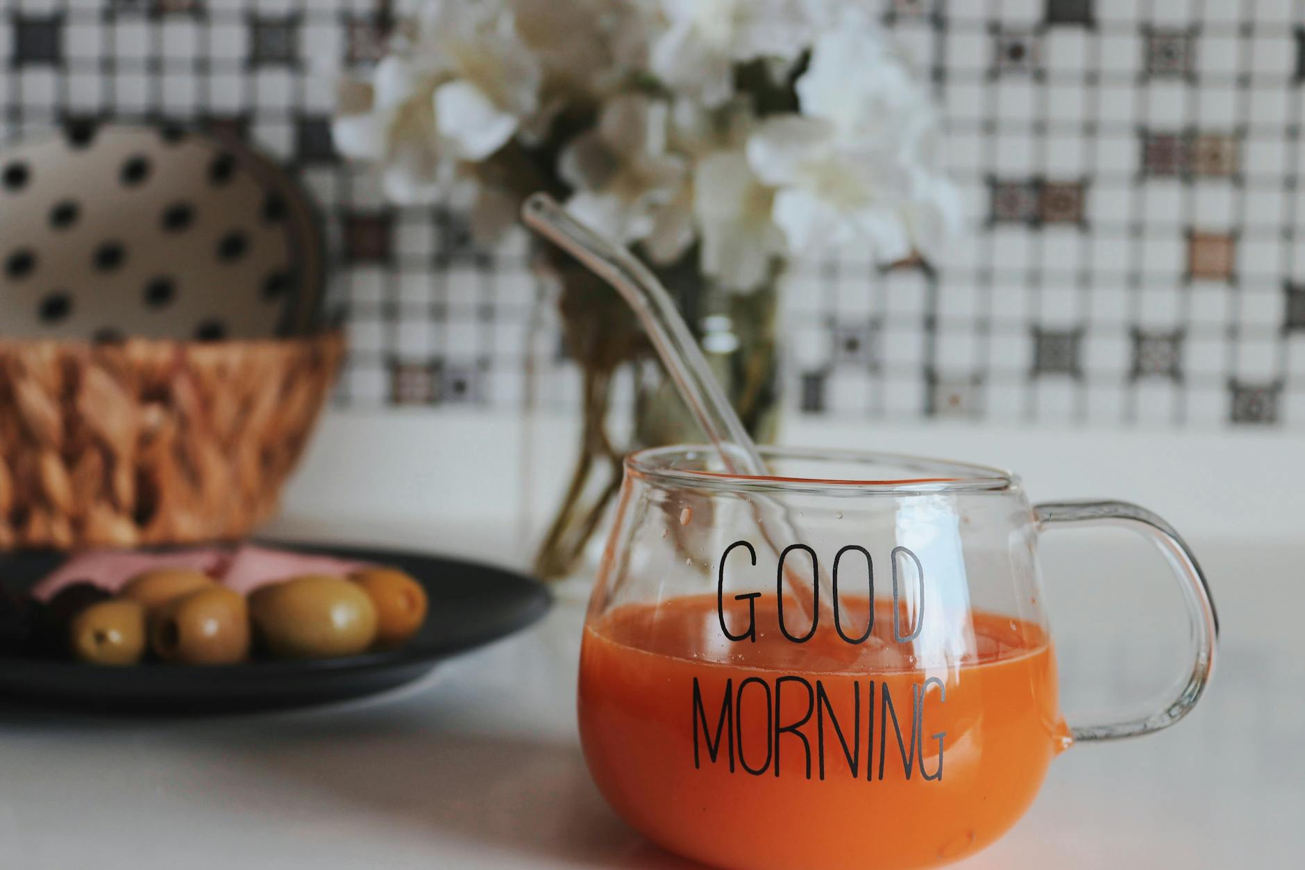 Szklanka soku pomarańczowego z napisem Good Morning na stole