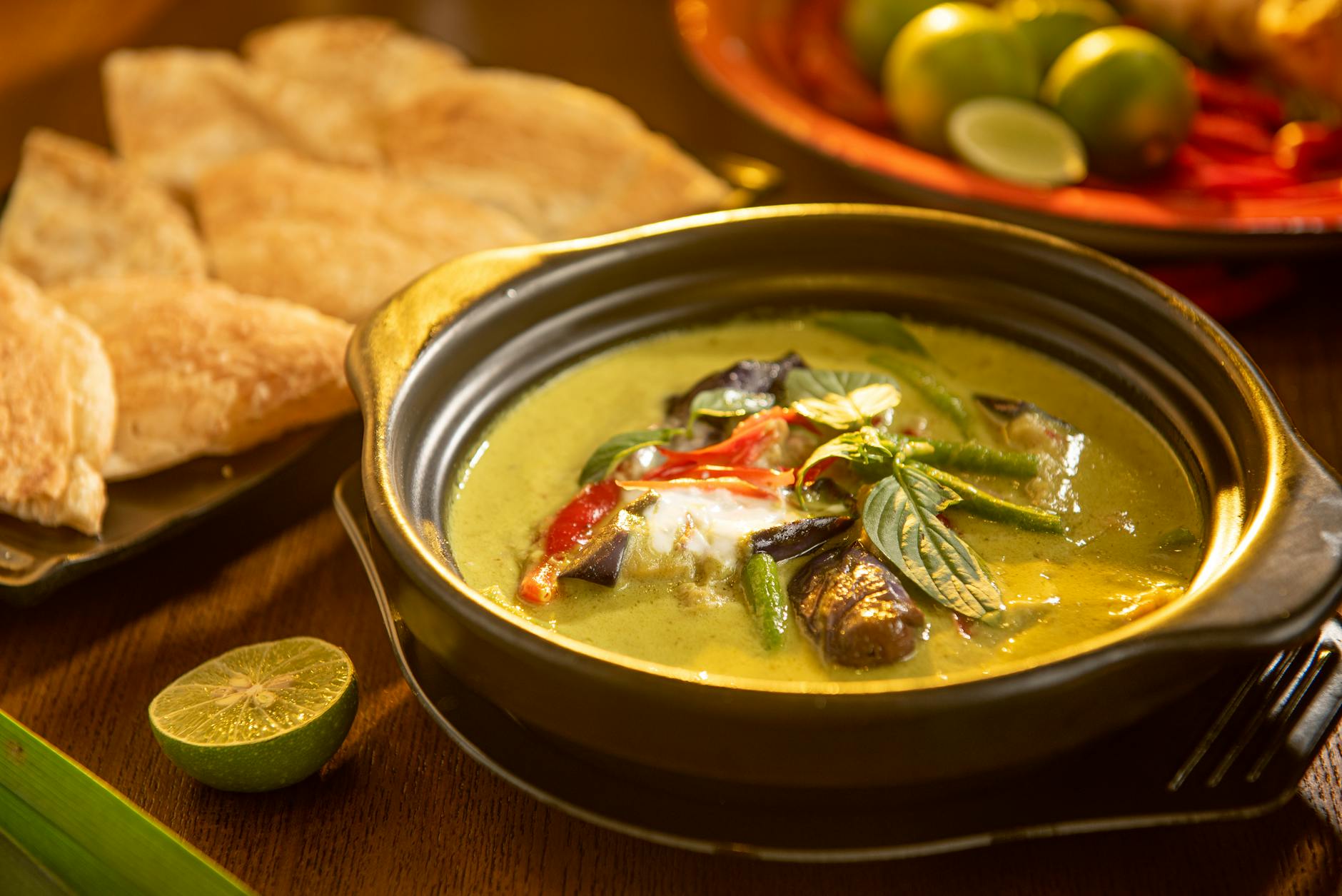 Zielone tajskie curry z warzywami i ziołami w czarnej misce