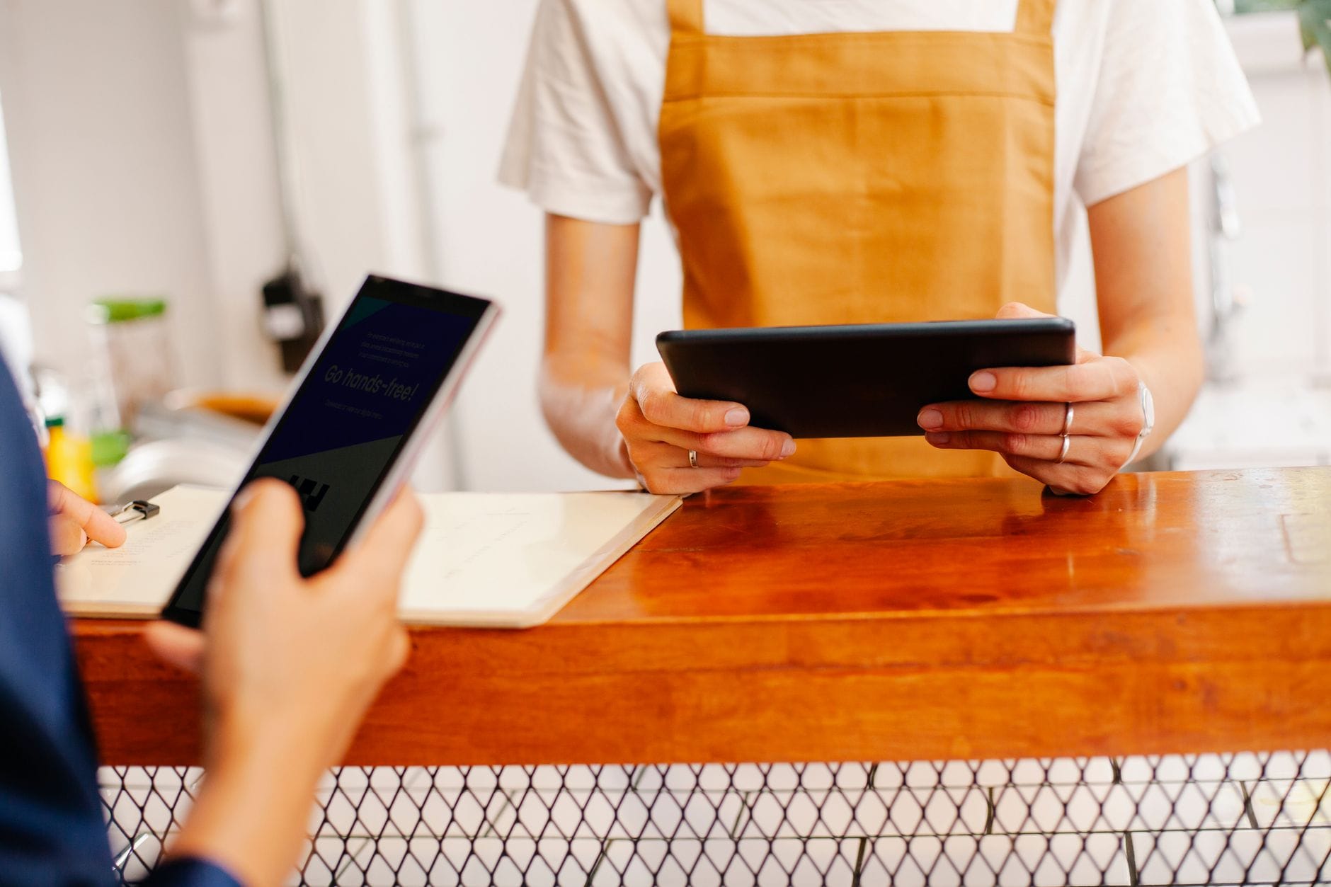 Dwie kobiety w kawiarni analizują dane na smartfonie i tablecie
