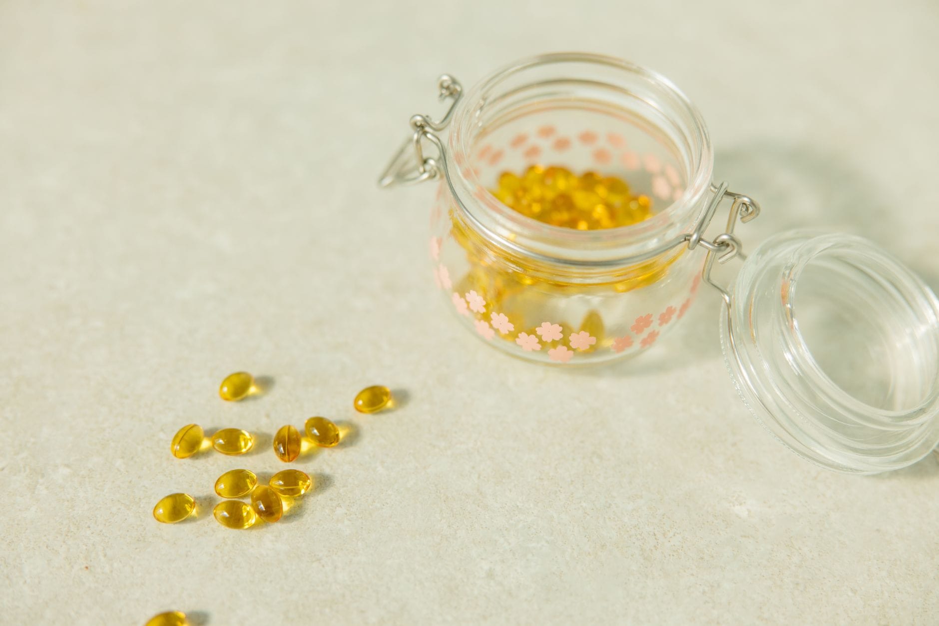 Szklany słoik z żółtymi kapsułkami suplementu omega-3